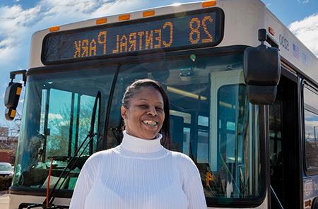 塔莎Clavo stands in front of her bus, which operates on route 28